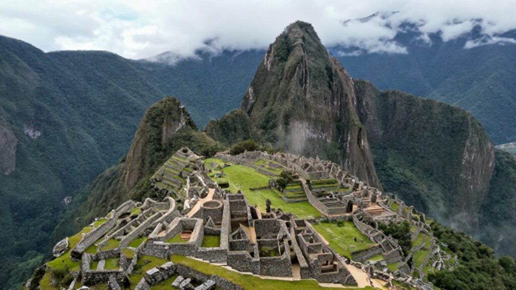 Vista aérea de la fortaleza de Kuélap con sus muros de piedra y estructuras circulares entre la densa vegetación y la neblina de los Andes peruanos.