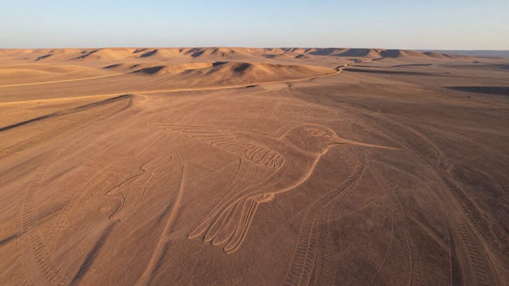 Vista aérea de un enorme geoglifo con forma de colibrí trazado sobre el desierto de Nazca en Perú.