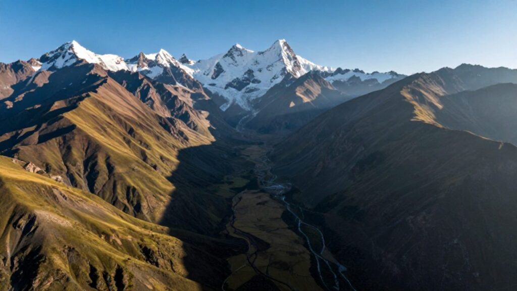 Paisaje de la cordillera de los Andes en Perú con picos nevados, glaciares y valles verdes que se extienden hacia el horizonte.